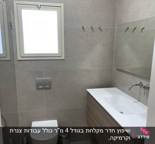 חדר אמבטיה משופץ עם כיור חדש וקיר אריחים